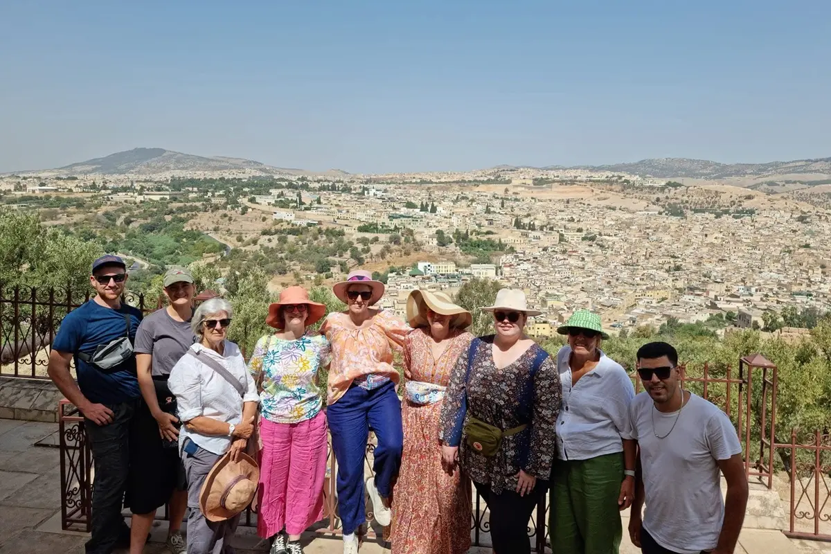 Travelers enjoying a panoramic view over Fes Medina during a 7-day Morocco desert tour from Fes
